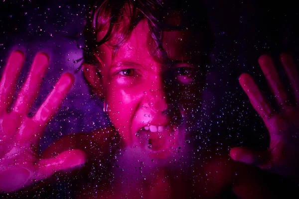 Kırpılmış Agresif Çocuk Cam Duvarın Arkasından Neon Işıklarla Bağırırken Kameraya — Stok fotoğraf