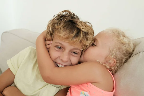 Χαρούμενο Κοριτσάκι Ξανθά Μαλλιά Αγκαλιάζει Και Φιλιά Χαμογελαστό Αδελφό Στον — Φωτογραφία Αρχείου