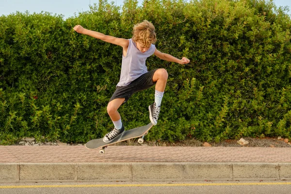Active Preteen Skater Jumping Skateboard Asphalt Road Showing Trick While — Stock Photo, Image