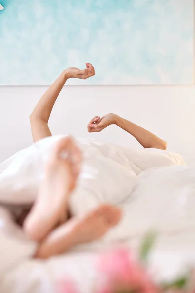 Анонимная Женщина Лежащая Постели Вытягивающая Руки Отдыхая Дома Выходные Утром — стоковое фото