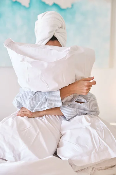 Nierozpoznawalna Kobieta Piżamie Obejmująca Miękkie Poduszki Ukrywająca Twarz Siedząc Łóżku — Zdjęcie stockowe