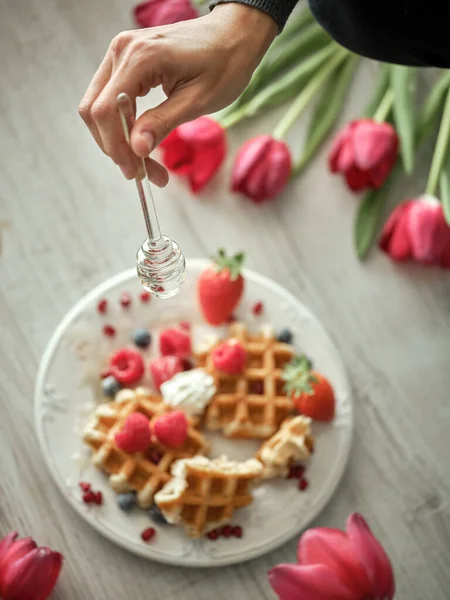 Crop Anonymous Person Pouring Honey Sweet Baked Waffles Ripe Berries — Stock Photo, Image