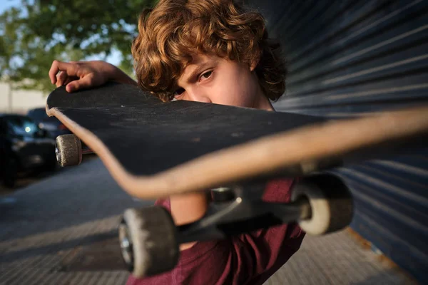 Gericht Jongen Met Krullend Haar Onderzoeken Skateboard Terwijl Staan Stoep — Stockfoto