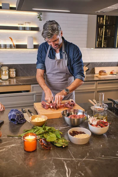 Vrolijke Oudere Man Schort Vlees Snijden Voor Smakelijke Schotel Houten — Stockfoto