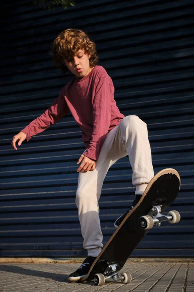 Junge Mit Skateboard Trick Auf Bürgersteig Gegen Dunkelblaue Wand Sonnigem — Stockfoto