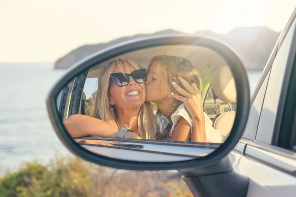 Lustro Samochodowe Wizerunkiem Blond Córki Całującej Się Przytulającej Swoją Matkę — Zdjęcie stockowe