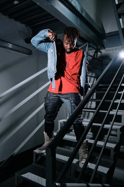Genç Şık Siyah Erkek Loş Işıkta Merdivenlerde Dikilirken Aşağı Bakıyor — Stok fotoğraf
