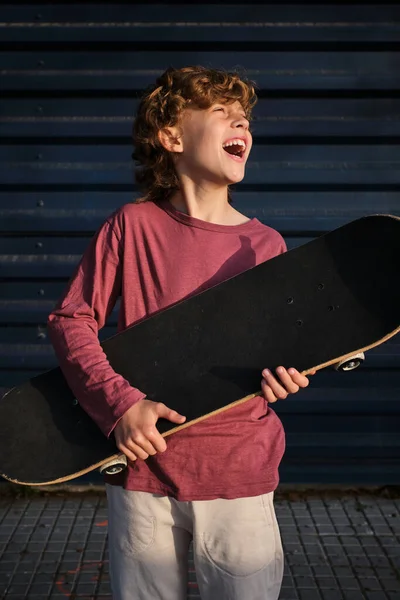 Happy Λίγο Σκέιτερ Skateboard Γέλιο Και Κοιτάζοντας Μακριά Ενώ Στηρίζεται — Φωτογραφία Αρχείου