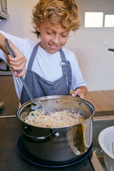 Crop Cheerful Child Mixing Tasty Cooked Pasta Creamy Sauce Pot — Stock Photo, Image