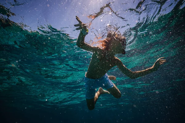 夏休みの間 澄んだ海水でダイビングマスクでシュノーケリング少年の低角度 — ストック写真