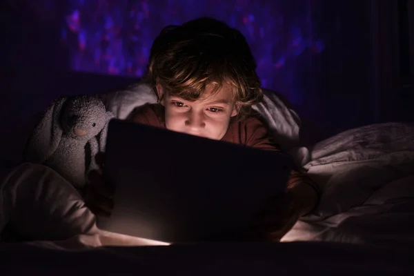 Leuke Jongen Slaapkledij Liggend Bed Onder Deken Tijdens Het Browsen — Stockfoto