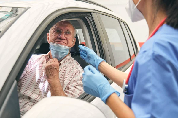 Crop Unrecognizable Female Medic Cotton Swab Talking Elderly Male Driver — Stock Photo, Image