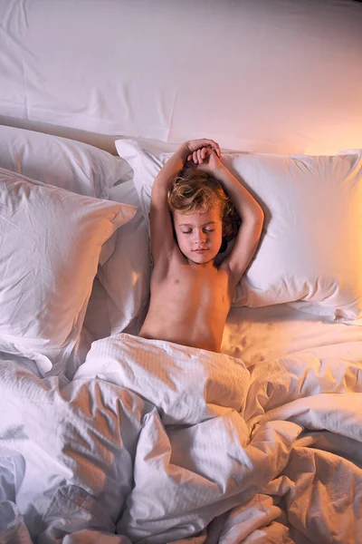 Kollarını Kaldırmış Yumuşak Bir Yatakta Yorganın Altına Uzanmış Akşamları Evde — Stok fotoğraf