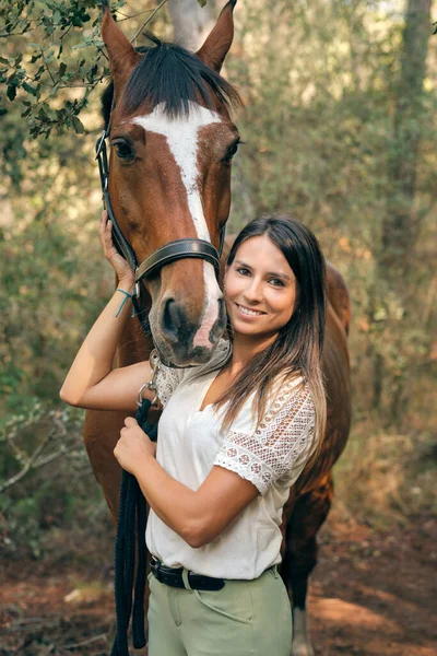 Восхитительная Женщина Конница Обнимает Коричневую Лошадь Трогает Морду Стоя Лесу — стоковое фото