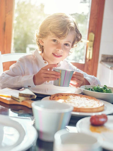 Netter Kleiner Junge Frühstückt Und Sitzt Tisch Während Esszimmer Lächelt — Stockfoto