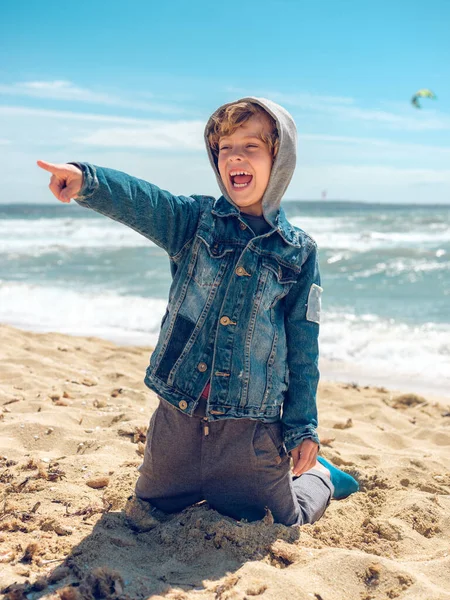 Glückliches Kleines Kind Jeansjacke Mit Kapuze Sitzt Sandstrand Der Nähe — Stockfoto
