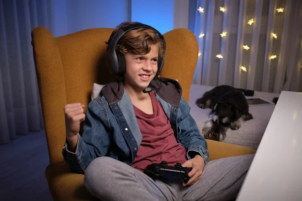 Θετικό Προεφηβικό Αγόρι Ακουστικά Κάθεται Άνετη Πολυθρόνα Gamepad Και Γιορτάζει — Φωτογραφία Αρχείου