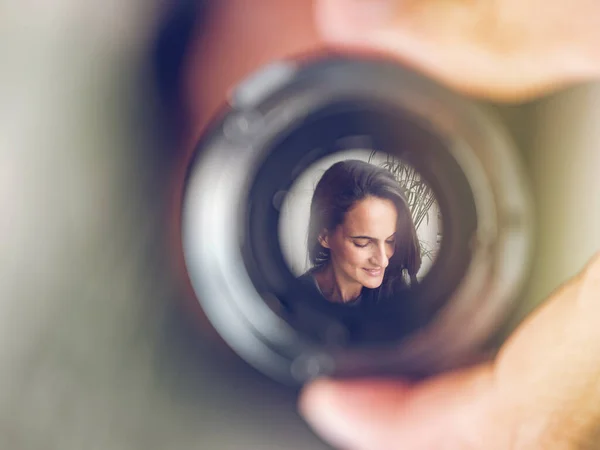 Zbliżenie Ręki Trzymając Obiektyw Kamery Odbiciem Uśmiechniętej Delikatnej Kobiety Długimi — Zdjęcie stockowe
