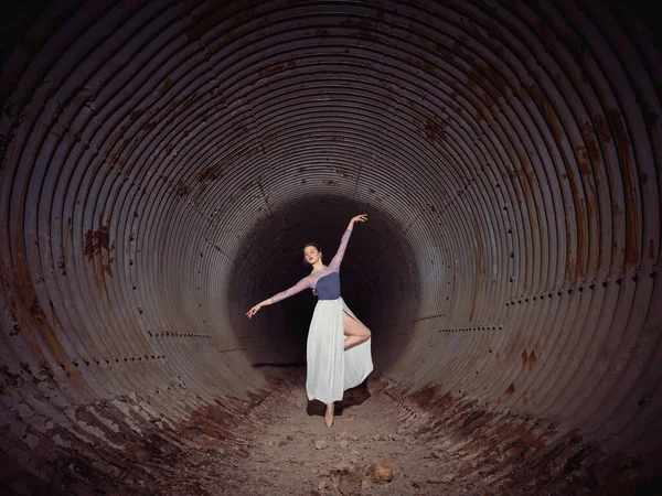 全身上下都是身材苗条的女芭蕾舞演员 她们单腿站立 在被忽略的隧道里跳舞 墙壁破烂不堪 — 图库照片