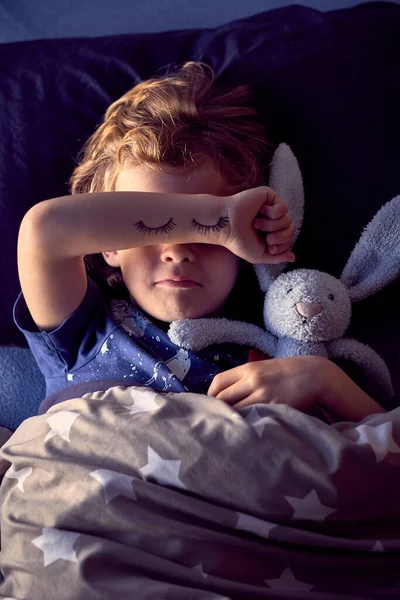 手で目を覆っているかわいい少年 手で塗られた目 ウサギのおもちゃの眠った子供 — ストック写真