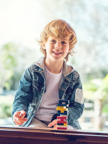 Rozkošný Chlapeček Bundě Sedí Stolu Dvorku Při Hraní Deskové Hry — Stock fotografie