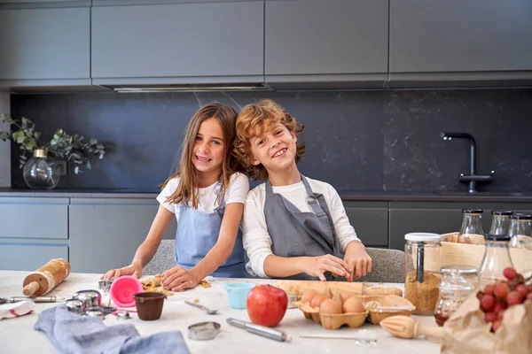 Delighted Children Aprons Looking Camera While Kneading Sweet Cookie Dough — Stock Photo, Image