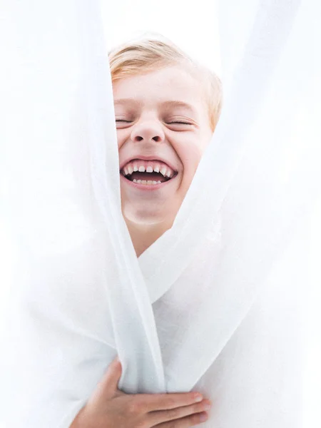 Roztomilý Chlapec Smíchem Zavřenýma Očima Ústy Otevřel Zakrývající Tělo Bílou — Stock fotografie