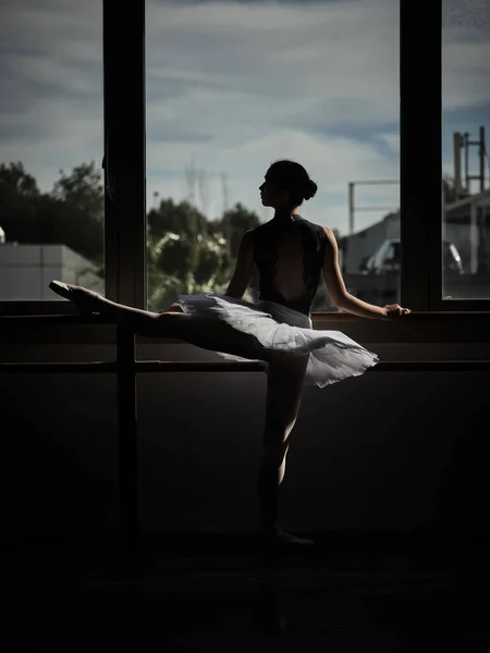 晚上排练时 身材苗条的芭蕾舞演员站在芭蕾舞团前 伸腿的背影 — 图库照片