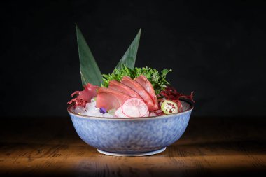 Muz yapraklarıyla süslenmiş taze balık fileto, turp ve kireç ile lezzetli sashimi ile kase.