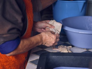 Mallorca 'daki geleneksel mezbahada sosis yaparken masada duran önlüklü tanınmayan çiftçinin yan görünüşü