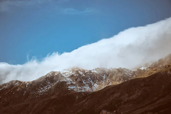 自然の晴れた日に厚い白い雲を持つ青空に対して位置する白いフロストで覆われたラフ山地帯 — ストック写真