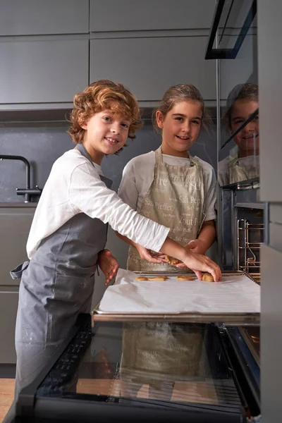 Wielorasowe Dzieci Umieszczające Surowe Ciasto Patelni Pieca Otwartego Patrząc Aparat — Zdjęcie stockowe
