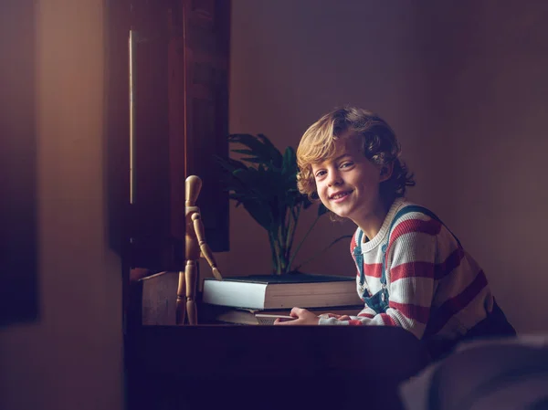Boční Pohled Šťastný Chlapec Sedí Stolu Okna Dívá Kameru Pozadí — Stock fotografie