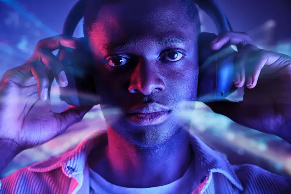Ciddi Afrika Kökenli Amerikalı Erkek Kulaklıkla Müzik Dinliyor Bulanık Işıklara — Stok fotoğraf