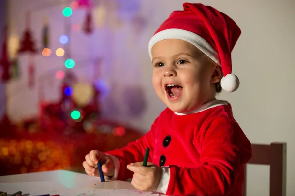 Glada Pojke Santa Kostym Sitter Vid Bordet Med Pennor Samtidigt — Stockfoto