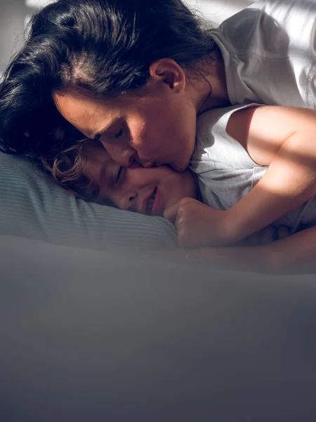 Şefkatli Anne Sevimli Oğlanın Yanağını Öpüyor Rahat Beyaz Bir Yatak — Stok fotoğraf