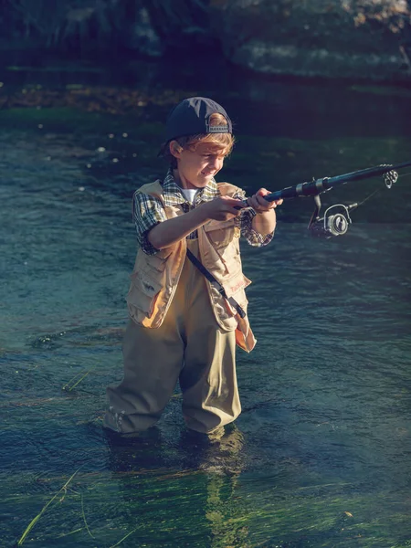 Niño Concentrado Pantalones Impermeables Gorra Tirando Pescado Con Caña Mientras —  Fotos de Stock
