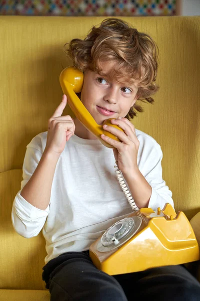 Optymistyczny Chłopiec Kręconymi Włosami Rozmawiający Zabytkowym Telefonie Stacjonarnym Patrzący Uśmiechem — Zdjęcie stockowe