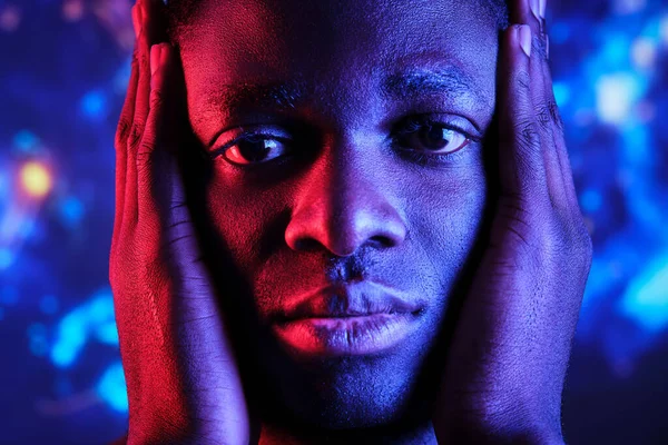 Trauriger Afroamerikaner Mit Den Händen Gesicht Gegen Bunte Lichter Die — Stockfoto