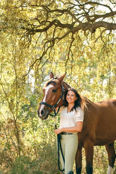 Восхитительная Женщина Конница Обнимает Коричневую Лошадь Стоя Зеленом Летнем Лесу — стоковое фото