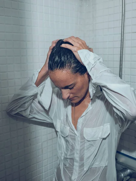 Zmęczenie Kobiety Mokrej Koszuli Stojącej Pod Rozpryskaną Wodą Kabinie Prysznicowej — Zdjęcie stockowe