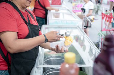 İspanyol bir yetişkin kadın sokakta vanilyalı dondurma topları servis ediyor. Geleneksel Meksika tatlısı kavramı