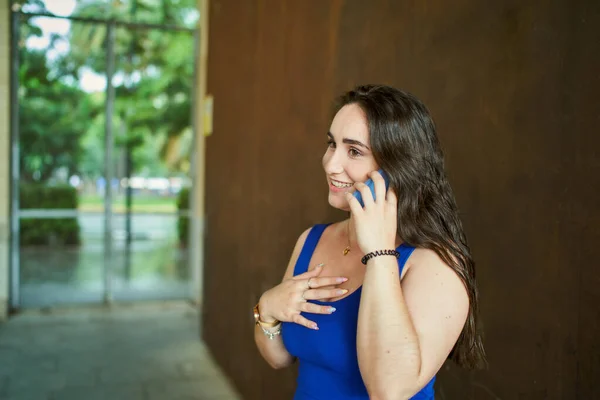Donna Sorridente Che Parla Cellulare Con Gesto Sorpreso Davanti Muro — Foto Stock