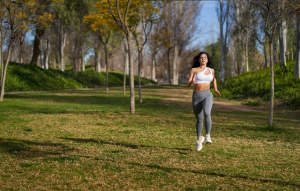 一个女运动员在公园里跑来跑去 头发低垂 从前面看去 — 图库照片