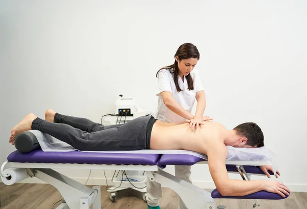 Physiotherapeut Behandelt Eine Kontraktion Rücken Des Patienten — Stockfoto