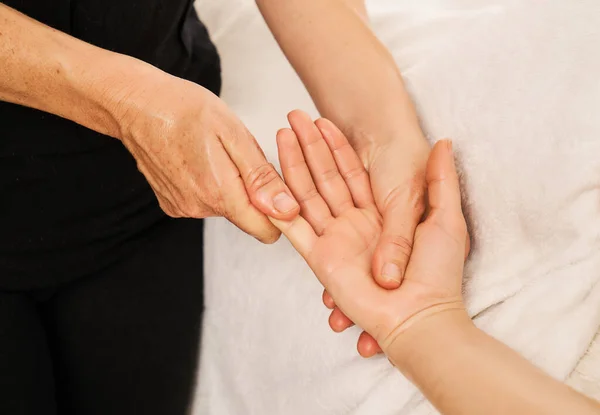 a woman gives a hand massage to relieve tension