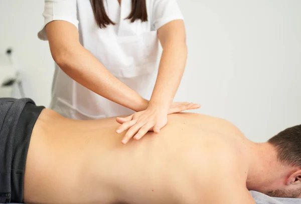 Physiotherapeut Behandelt Eine Kontraktion Rücken Des Patienten — Stockfoto