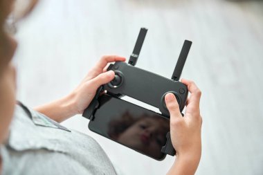 Modern uzaktan kumandanın konsol tuşlarına basan isimsiz ergen çocuktan