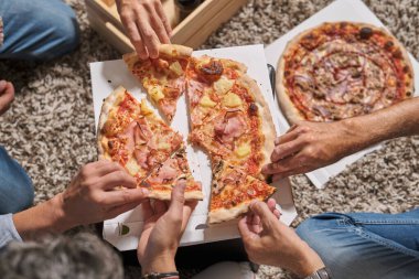 Yukarıdaki meçhul erkek arkadaşlar toplanıyor ve hafta sonu parti yaparken lezzetli pizzalardan dilimler yiyorlar.