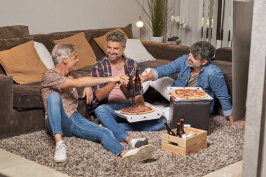 Hafta sonu partisinde oturma odasında oturup bira içen neşeli arkadaşlarla dolu.